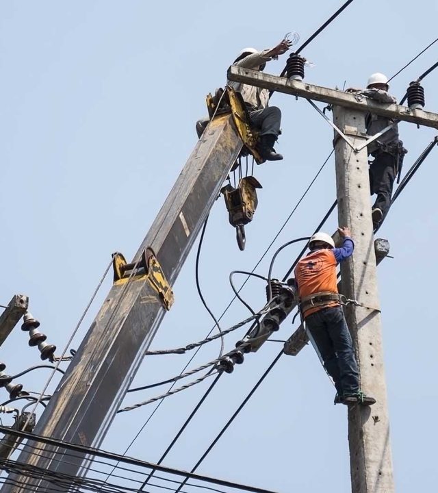 Selective focus of electricians are fixing power transmission line on a electricity pole